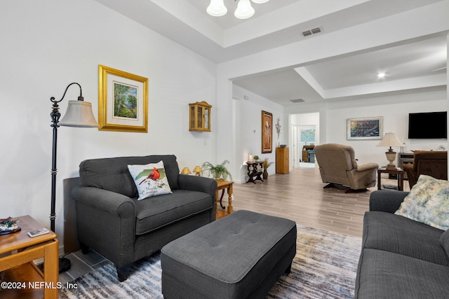 living room featuring a raised ceiling and hardwood / wood-style floors