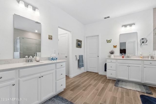 bathroom with hardwood / wood-style flooring, vanity, and walk in shower