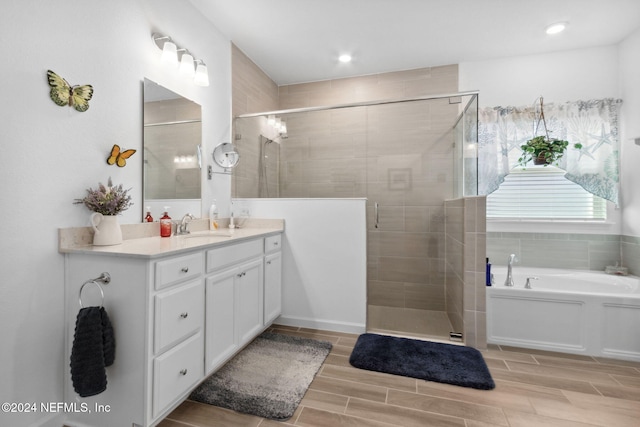 bathroom featuring plus walk in shower and vanity