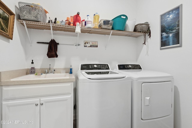 laundry area featuring washer and clothes dryer, cabinets, and sink