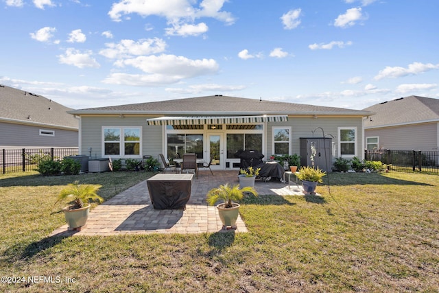 rear view of house with a yard and a patio