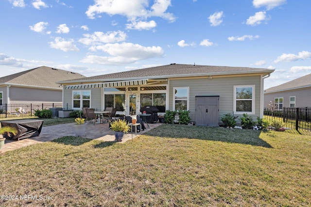 back of property with a yard and a patio