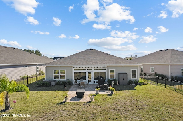 rear view of house with a patio and a lawn