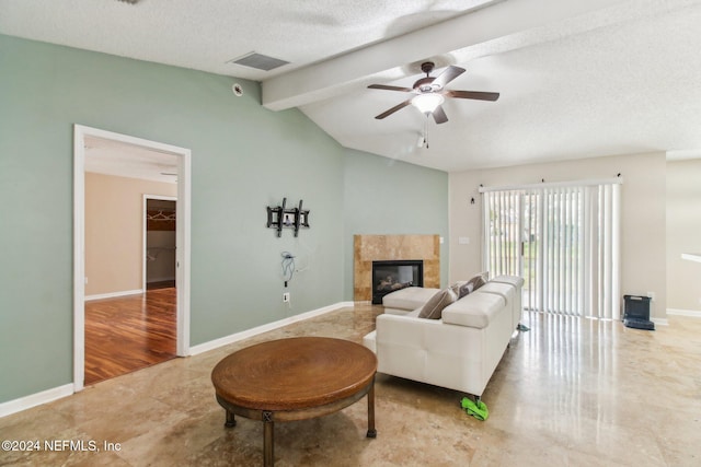 living room with a textured ceiling, ceiling fan, wood-type flooring, lofted ceiling with beams, and a fireplace