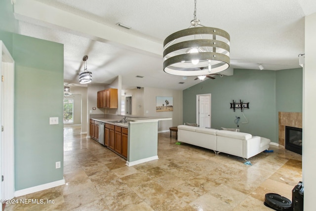 kitchen featuring pendant lighting, sink, vaulted ceiling, a fireplace, and a notable chandelier