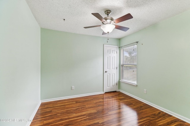 empty room featuring ceiling fan, dark hardwood / wood-style flooring, and a textured ceiling