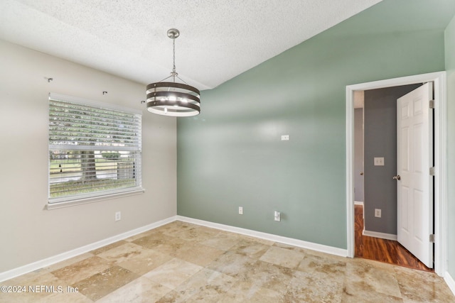 unfurnished room with hardwood / wood-style flooring, a textured ceiling, and a chandelier