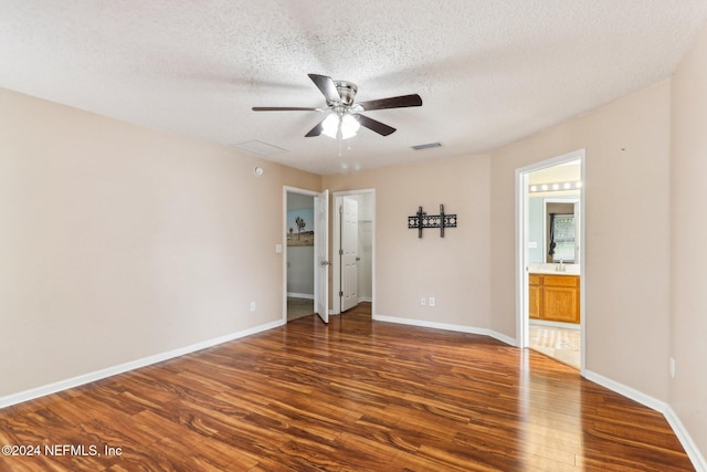 unfurnished room featuring a textured ceiling, ceiling fan, and dark wood-type flooring