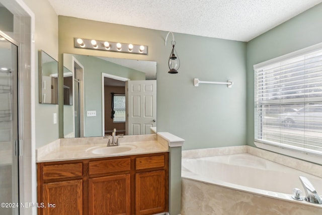 bathroom with vanity, a textured ceiling, and independent shower and bath