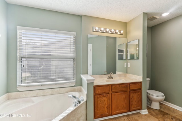 bathroom featuring a tub, vanity, a textured ceiling, and toilet