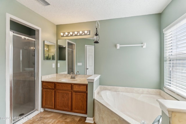 bathroom featuring separate shower and tub, vanity, and a textured ceiling