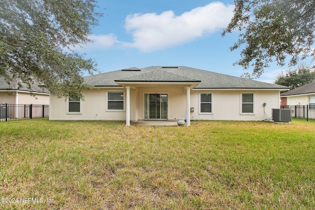 rear view of property with a lawn and central air condition unit