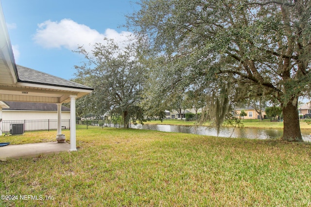 view of yard featuring a water view and central air condition unit