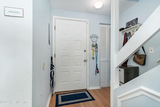 entryway featuring a textured ceiling and light hardwood / wood-style flooring