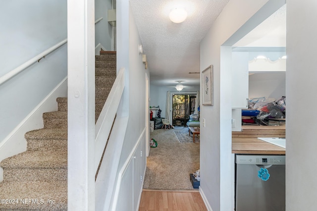 staircase with hardwood / wood-style flooring and a textured ceiling