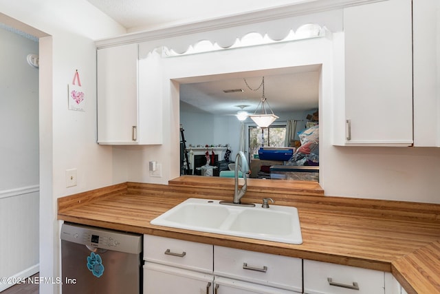 kitchen with stainless steel dishwasher, decorative light fixtures, white cabinetry, and sink