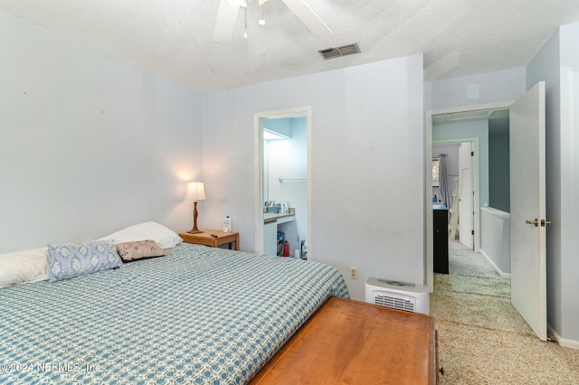 carpeted bedroom with a textured ceiling, heating unit, and ceiling fan