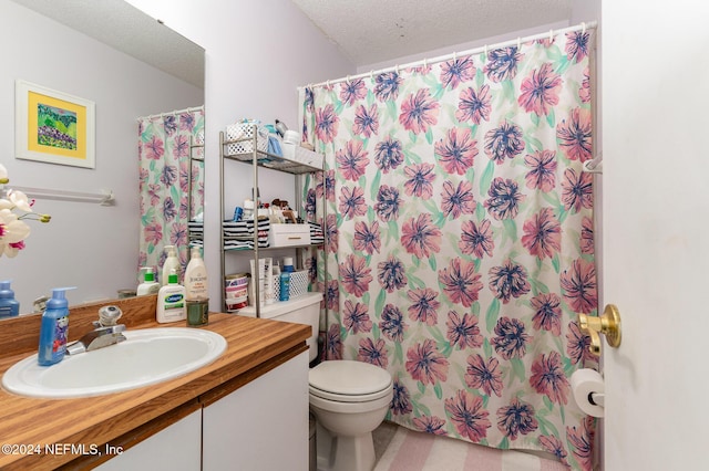 bathroom featuring vanity, a textured ceiling, and toilet