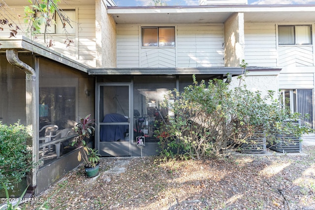 rear view of property featuring a sunroom