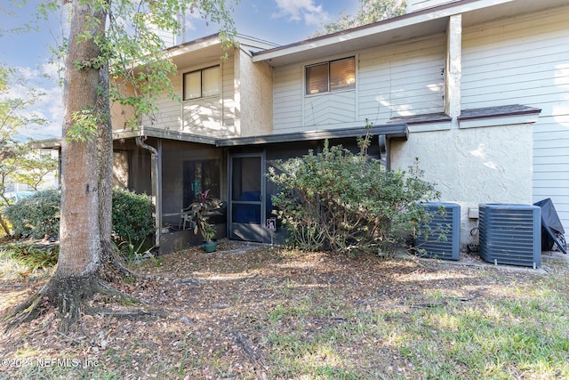 rear view of property featuring central AC and a sunroom