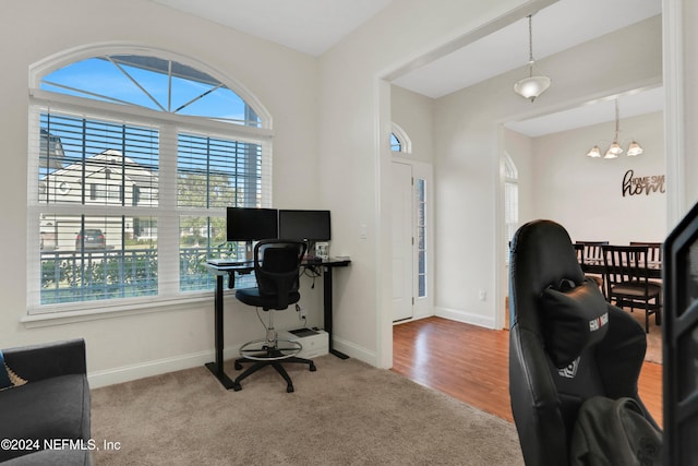 carpeted office space with an inviting chandelier