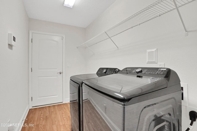 laundry room featuring wood-type flooring and washing machine and clothes dryer