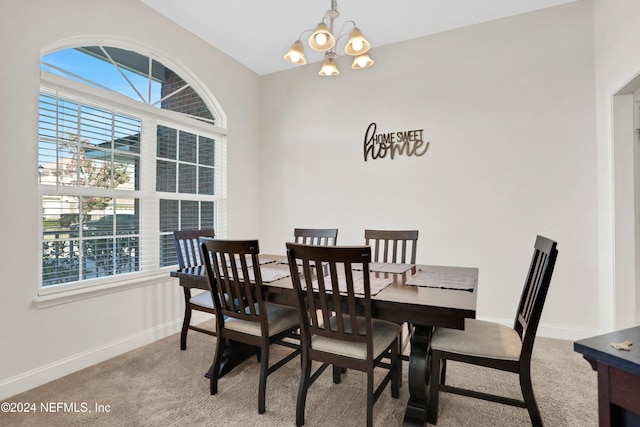 dining area with a notable chandelier, carpet floors, and vaulted ceiling