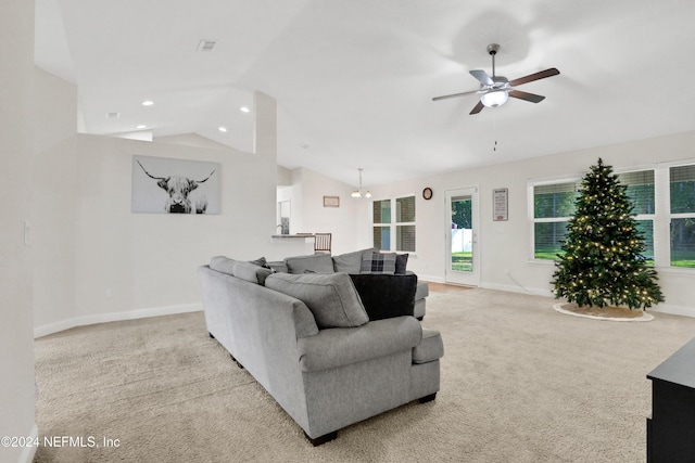 living room with ceiling fan with notable chandelier, light colored carpet, and lofted ceiling