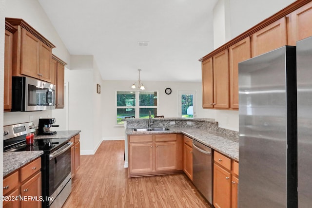 kitchen featuring sink, stainless steel appliances, light hardwood / wood-style flooring, a notable chandelier, and vaulted ceiling