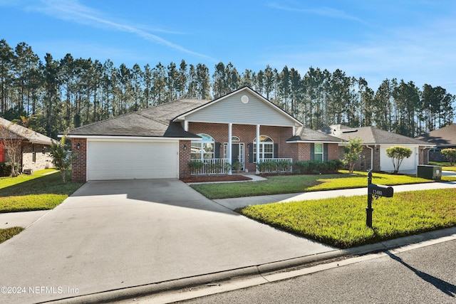 ranch-style house featuring covered porch, a front yard, and a garage