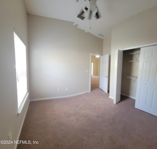 unfurnished bedroom with carpet floors, a closet, and multiple windows