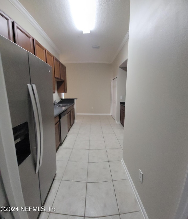 kitchen with light tile patterned floors, stainless steel appliances, crown molding, and sink