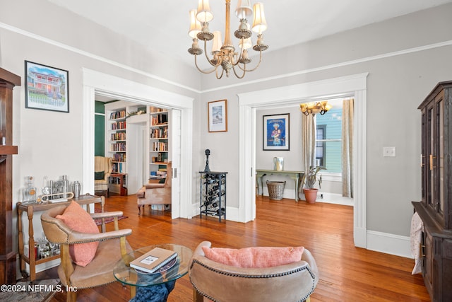 sitting room with hardwood / wood-style flooring and a chandelier