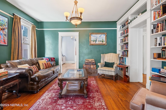 living room featuring wood-type flooring and an inviting chandelier