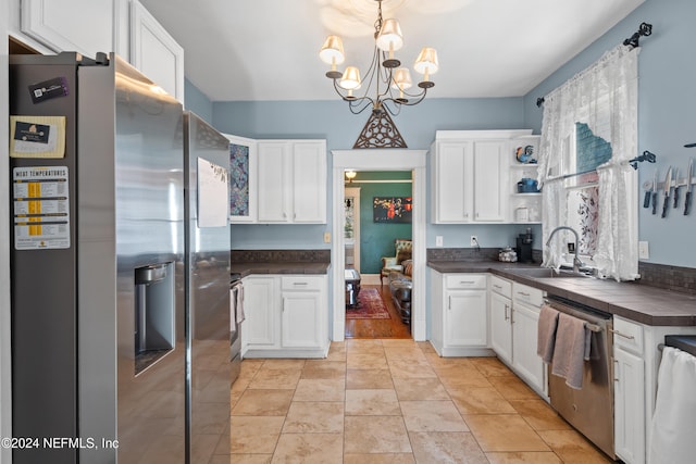 kitchen with a chandelier, appliances with stainless steel finishes, white cabinetry, and sink