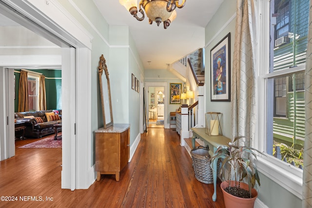 hallway with a notable chandelier and wood-type flooring