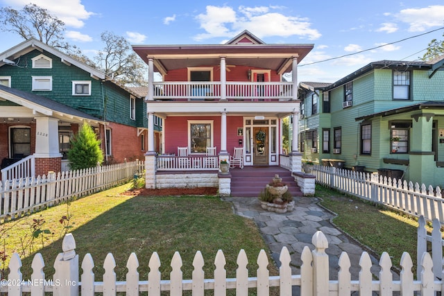 view of front of home with a porch, a balcony, and a front lawn