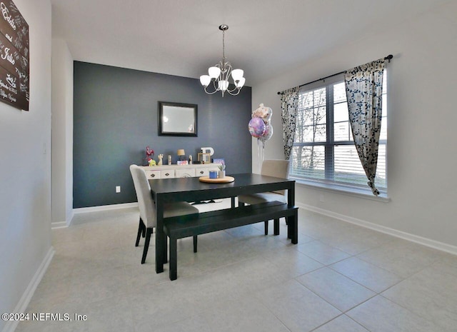 tiled dining room featuring a chandelier