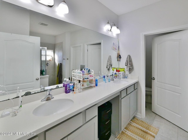 bathroom featuring tile patterned floors, vanity, toilet, and walk in shower