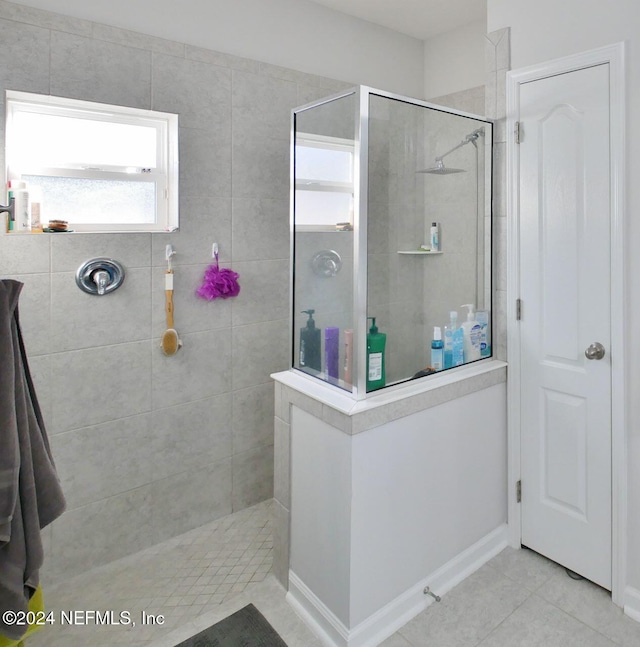 bathroom with tile patterned flooring and a tile shower