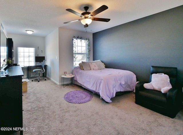 carpeted bedroom featuring a textured ceiling, multiple windows, and ceiling fan