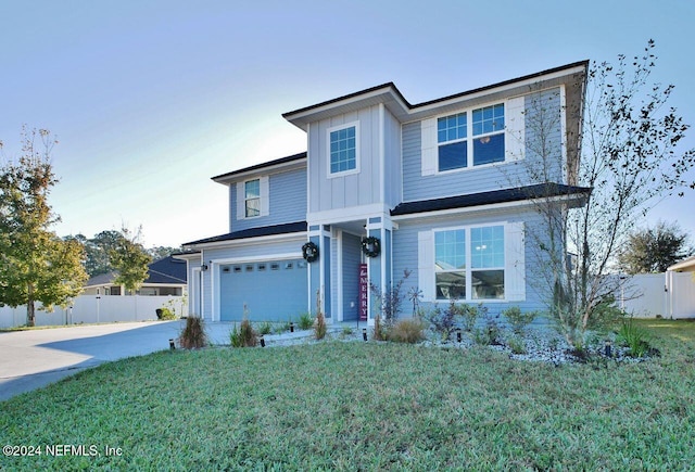 view of property featuring a garage and a front lawn