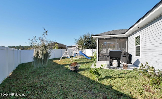 view of yard featuring a playground and a sunroom