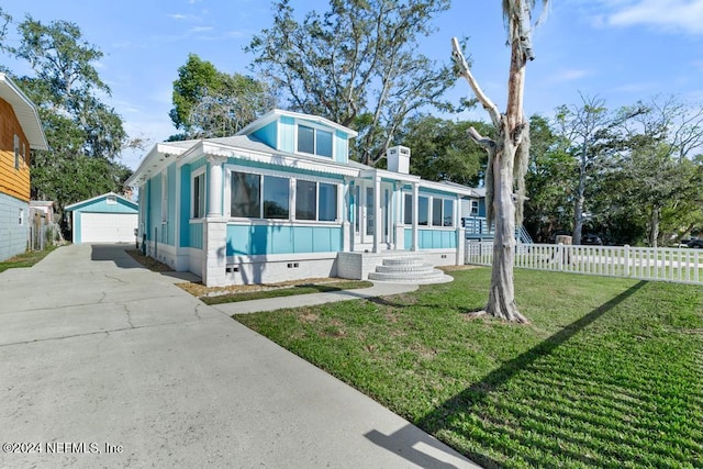 view of front of house with a porch, a garage, an outdoor structure, and a front yard