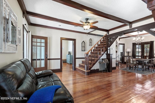 living room with beam ceiling, french doors, wood-type flooring, and a textured ceiling