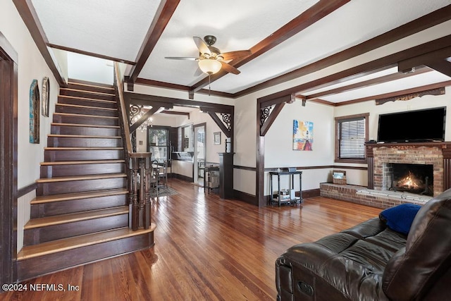 living room with crown molding, ceiling fan, a fireplace, a healthy amount of sunlight, and wood-type flooring