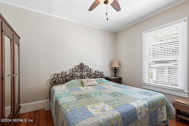 bedroom with a textured ceiling, crown molding, ceiling fan, and dark wood-type flooring