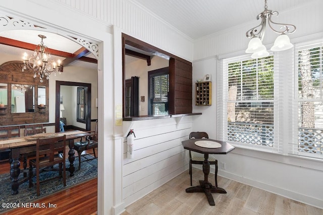 bathroom with hardwood / wood-style floors, crown molding, wooden walls, and an inviting chandelier