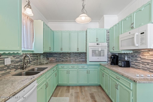 kitchen with decorative backsplash, white appliances, crown molding, sink, and pendant lighting