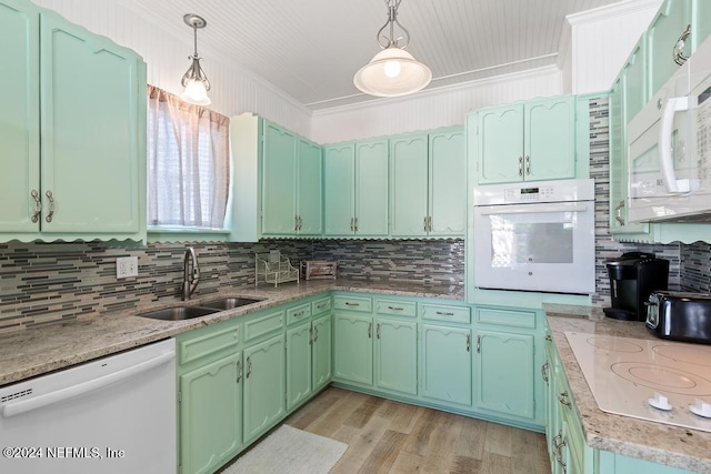 kitchen featuring crown molding, sink, decorative light fixtures, and white appliances